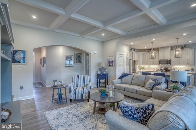 living room with beamed ceiling, coffered ceiling, and hardwood / wood-style floors