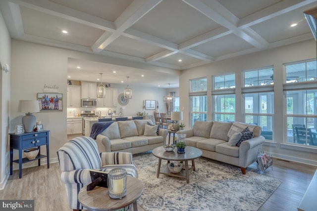 living room with beam ceiling, coffered ceiling, and light wood-type flooring