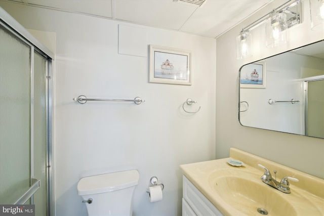 bathroom with vanity, an enclosed shower, and toilet