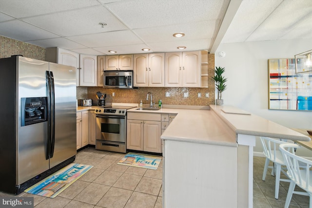 kitchen featuring tasteful backsplash, appliances with stainless steel finishes, sink, and kitchen peninsula