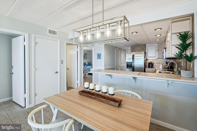 tiled dining room featuring sink