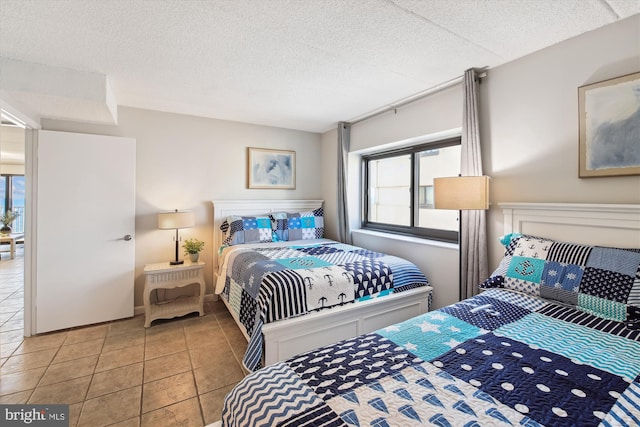 tiled bedroom featuring multiple windows and a textured ceiling