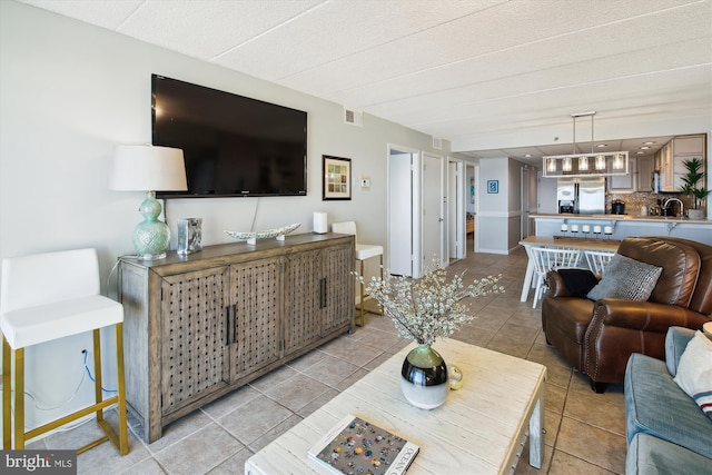 tiled living room featuring sink