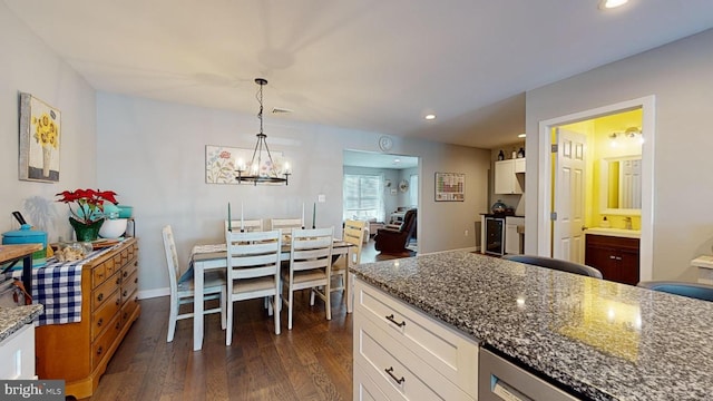 kitchen with pendant lighting, white cabinets, dark hardwood / wood-style flooring, and dark stone counters