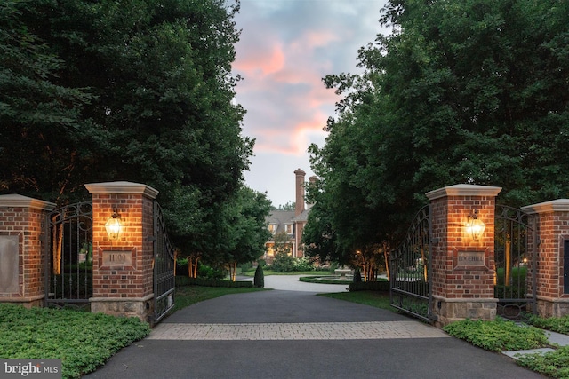 gate at dusk with an outdoor brick fireplace