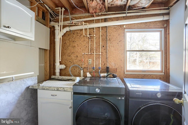 laundry area featuring separate washer and dryer, plenty of natural light, and cabinets