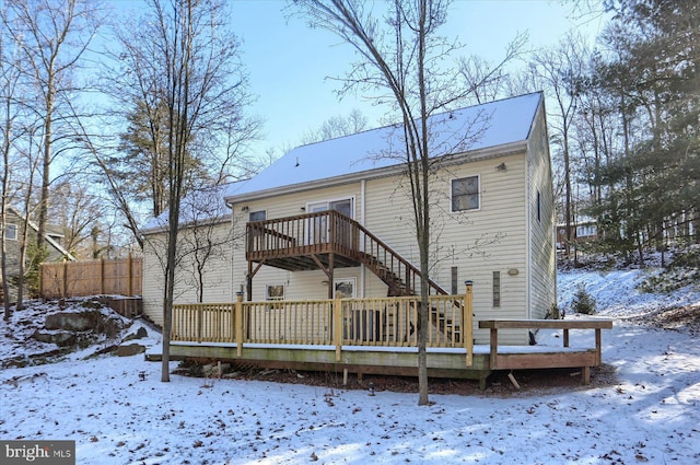 snow covered back of property featuring a wooden deck