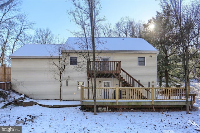 snow covered house with a wooden deck