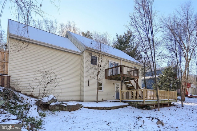 snow covered property with a wooden deck