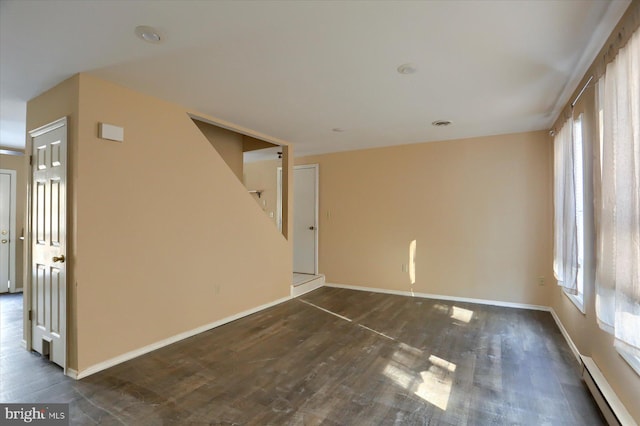 spare room featuring dark hardwood / wood-style floors and baseboard heating