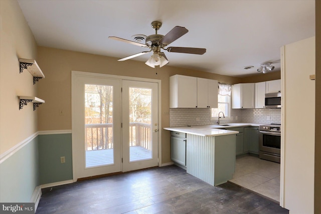 kitchen featuring sink, stainless steel appliances, white cabinets, dark hardwood / wood-style flooring, and decorative backsplash