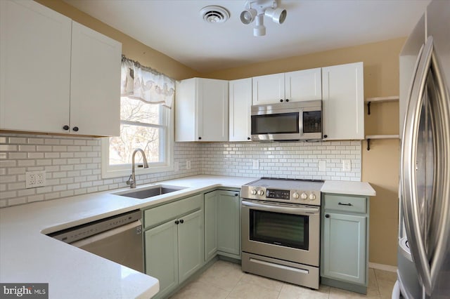 kitchen with white cabinetry, sink, decorative backsplash, and stainless steel appliances