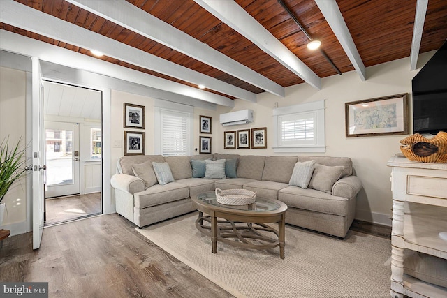 living room featuring beam ceiling, wood-type flooring, wooden ceiling, and a wall unit AC