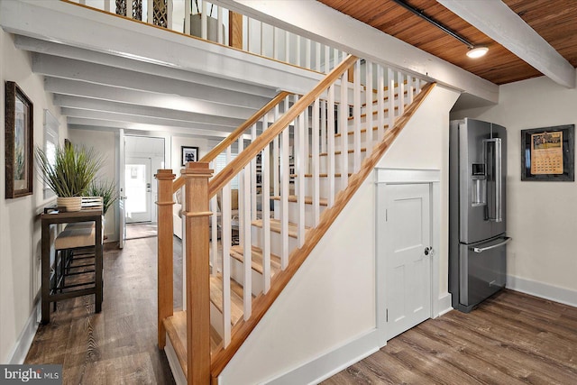 stairway featuring beamed ceiling, wood-type flooring, and wooden ceiling