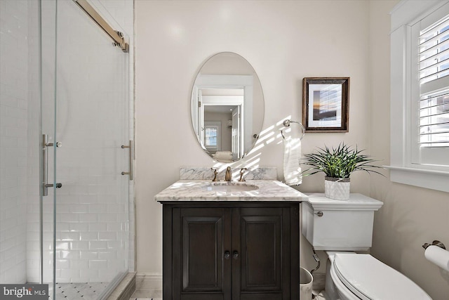 bathroom featuring vanity, toilet, and a shower with shower door