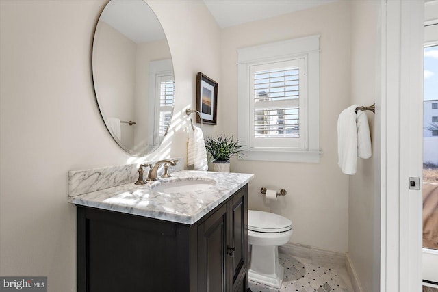 bathroom featuring vanity, toilet, and plenty of natural light