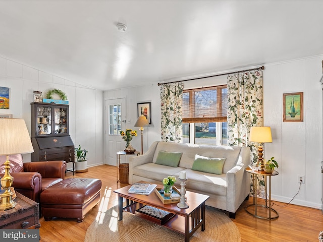 living room featuring plenty of natural light, lofted ceiling, and light hardwood / wood-style floors