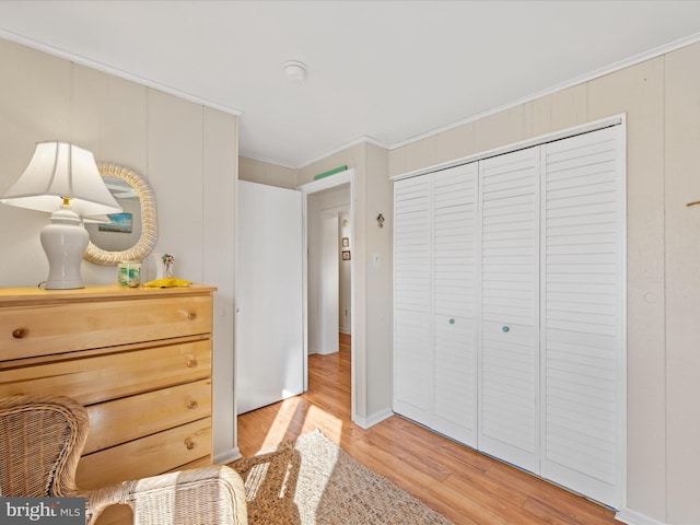 bedroom featuring ornamental molding and light hardwood / wood-style floors