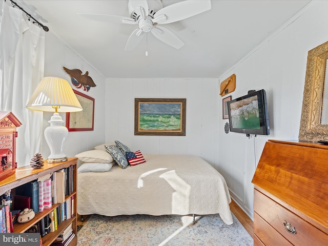 bedroom with wood-type flooring, ceiling fan, and crown molding