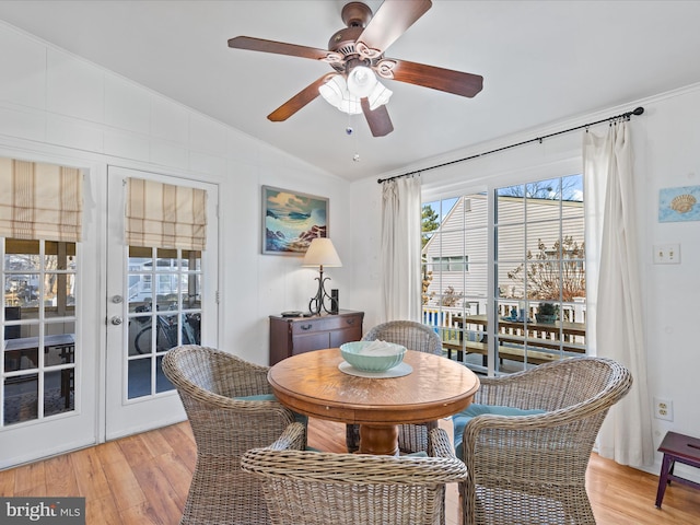 dining space with ceiling fan, lofted ceiling, and light wood-type flooring