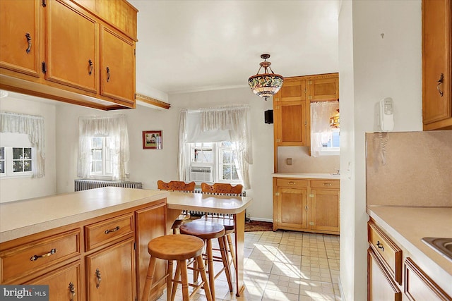 kitchen featuring radiator heating unit, plenty of natural light, pendant lighting, and a kitchen breakfast bar