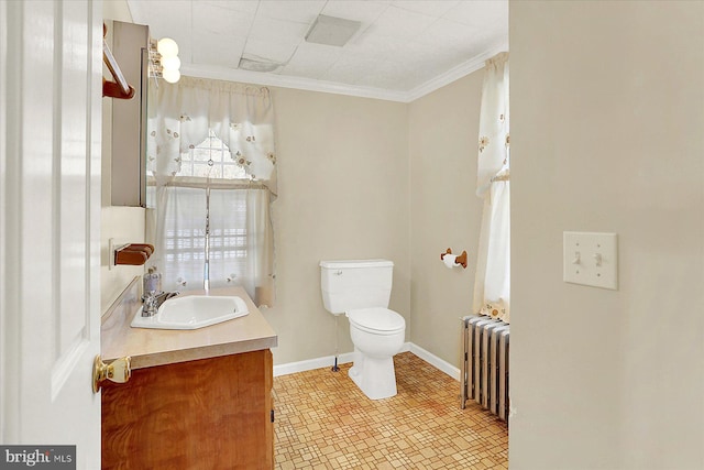 bathroom with radiator heating unit, vanity, ornamental molding, toilet, and tile patterned floors