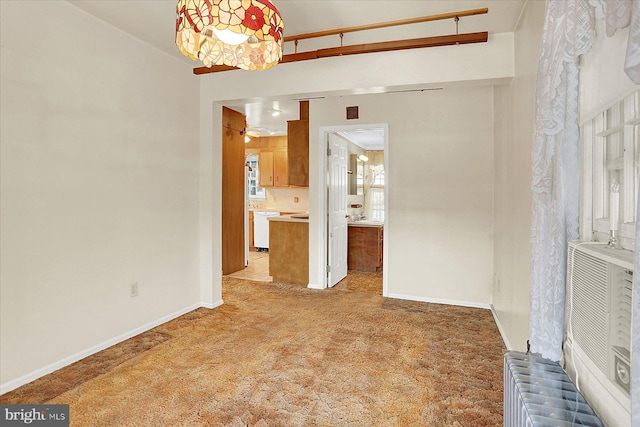 unfurnished living room with radiator heating unit and light carpet