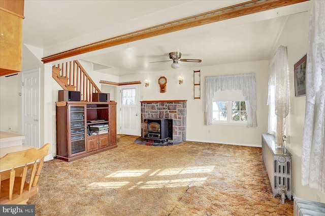 unfurnished living room featuring beam ceiling, carpet flooring, and ceiling fan