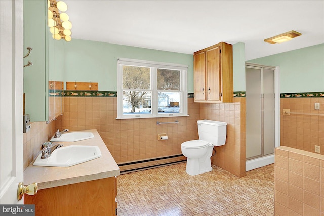 bathroom with tile walls, vanity, a baseboard radiator, and tile patterned floors