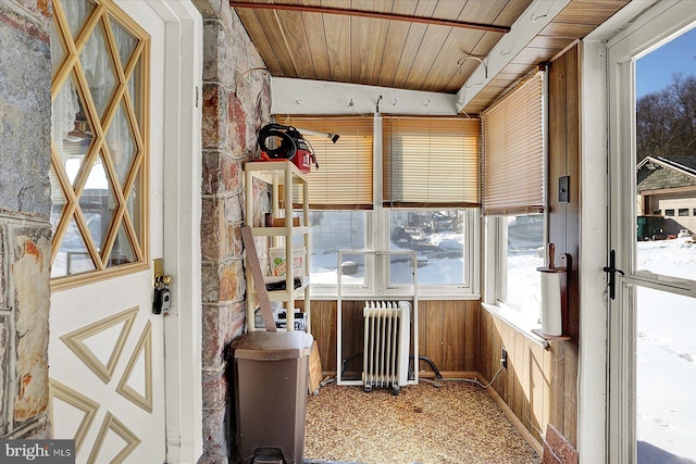 unfurnished sunroom featuring vaulted ceiling, radiator, and wood ceiling