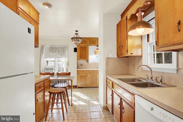 kitchen featuring tasteful backsplash, white appliances, sink, and hanging light fixtures