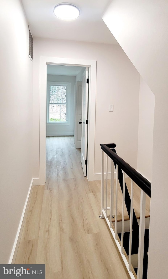 corridor with light hardwood / wood-style flooring