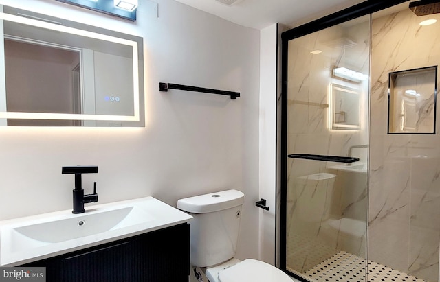 bathroom with vanity, a shower with shower door, and toilet