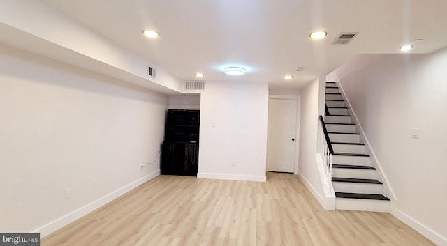 basement with light hardwood / wood-style flooring