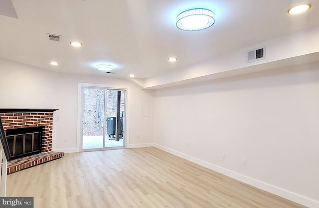 unfurnished living room featuring a fireplace and light hardwood / wood-style flooring