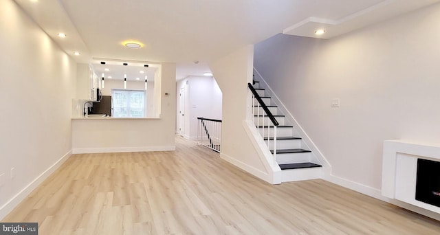 unfurnished living room with sink and light wood-type flooring