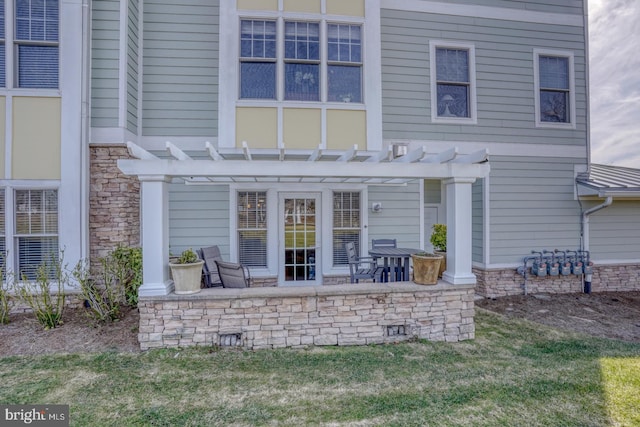 back of property with a pergola, a lawn, and a patio