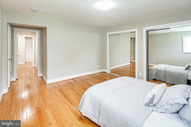 bedroom featuring wood-type flooring and multiple closets