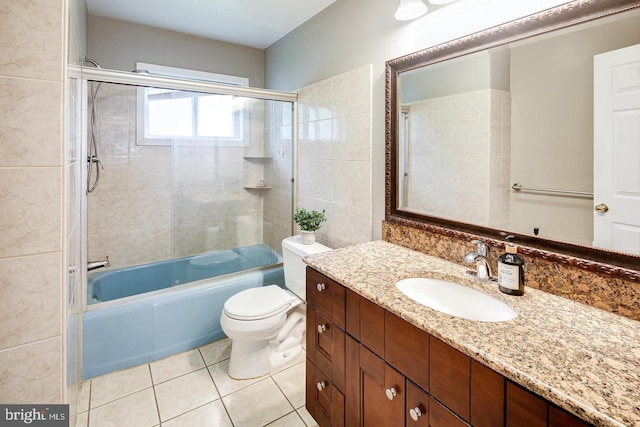 full bathroom featuring tiled shower / bath, vanity, toilet, and tile patterned flooring