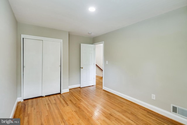 unfurnished bedroom with a closet and light wood-type flooring