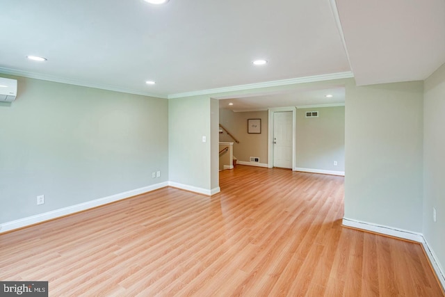 interior space featuring crown molding, a wall unit AC, and light wood-type flooring