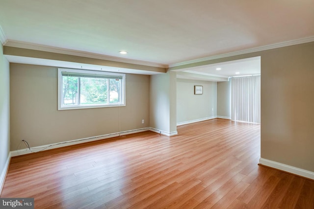 spare room with ornamental molding and light hardwood / wood-style floors