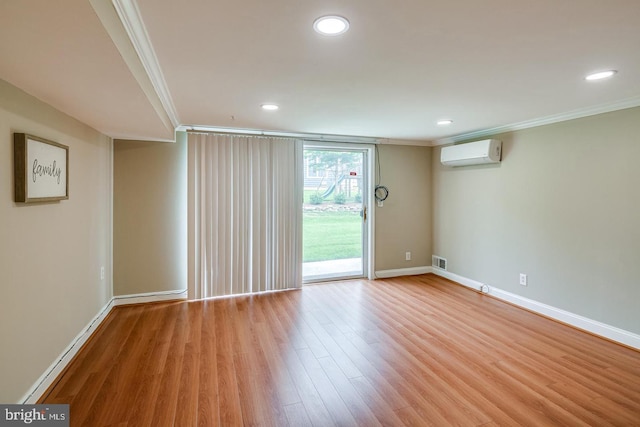 unfurnished room featuring ornamental molding, a wall mounted AC, and light wood-type flooring