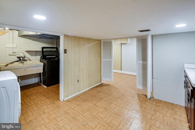 laundry area with light parquet flooring, washer / dryer, and sink