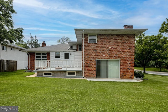 rear view of property featuring a lawn