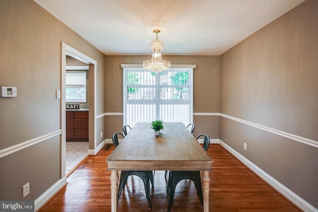 dining room with hardwood / wood-style flooring and a notable chandelier