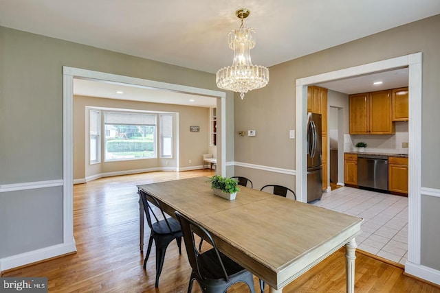 dining area featuring a notable chandelier and light hardwood / wood-style flooring