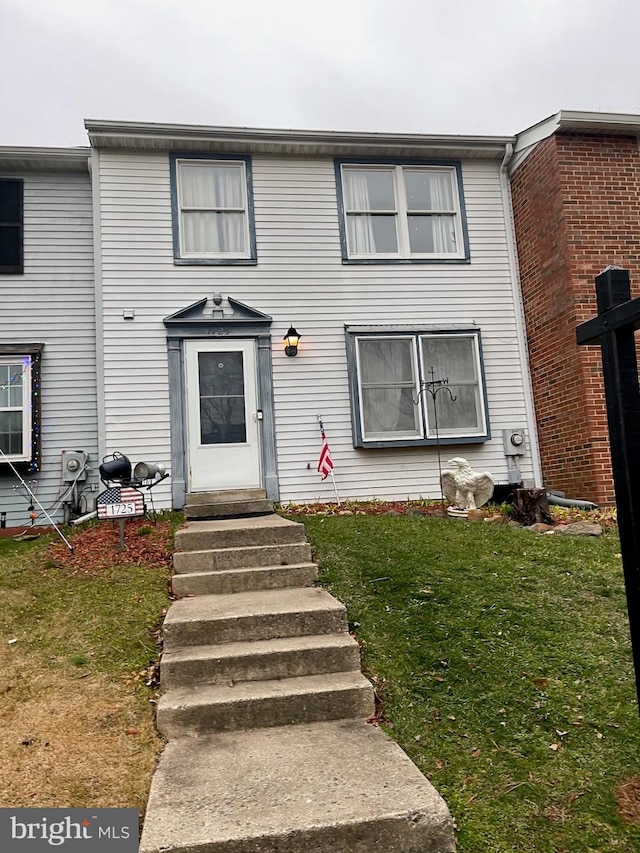 view of front of property featuring entry steps and a front yard