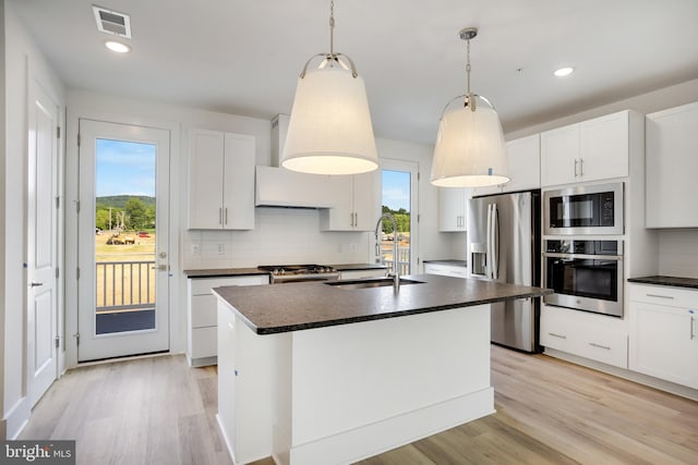 kitchen with pendant lighting, sink, a kitchen island with sink, white cabinetry, and stainless steel appliances