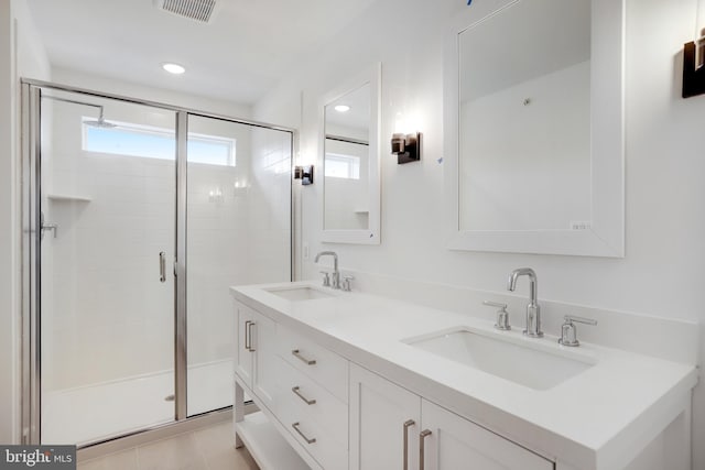 bathroom with walk in shower, vanity, and tile patterned flooring